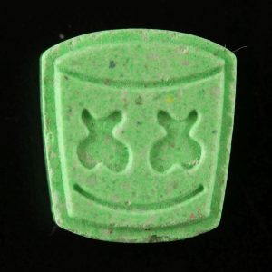 Marshmello MDMA pill in bright green color placed against a black surface. Marshmello MDMA For Sale